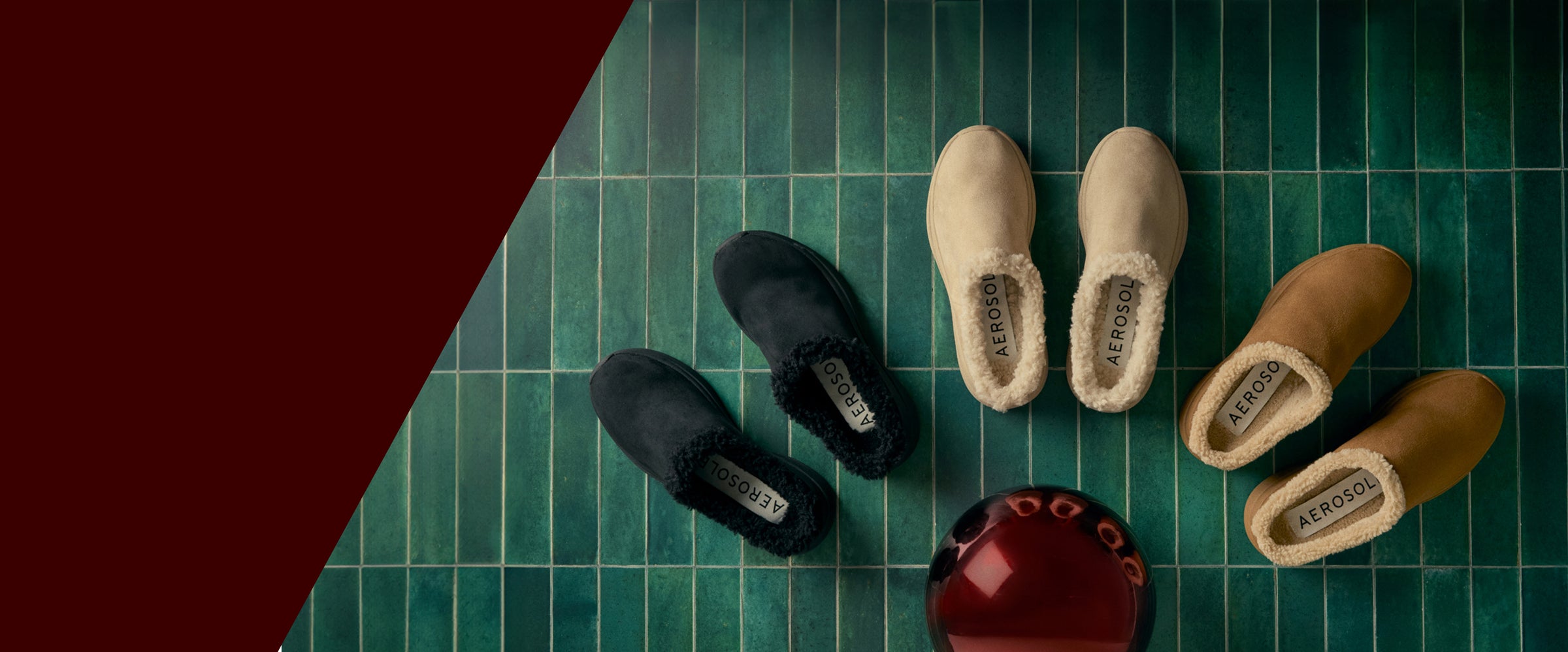 Pair of black shoes, beige slippers, and brown slippers on a green checkered surface. gifts they're sure to love. cozy comforts shop now