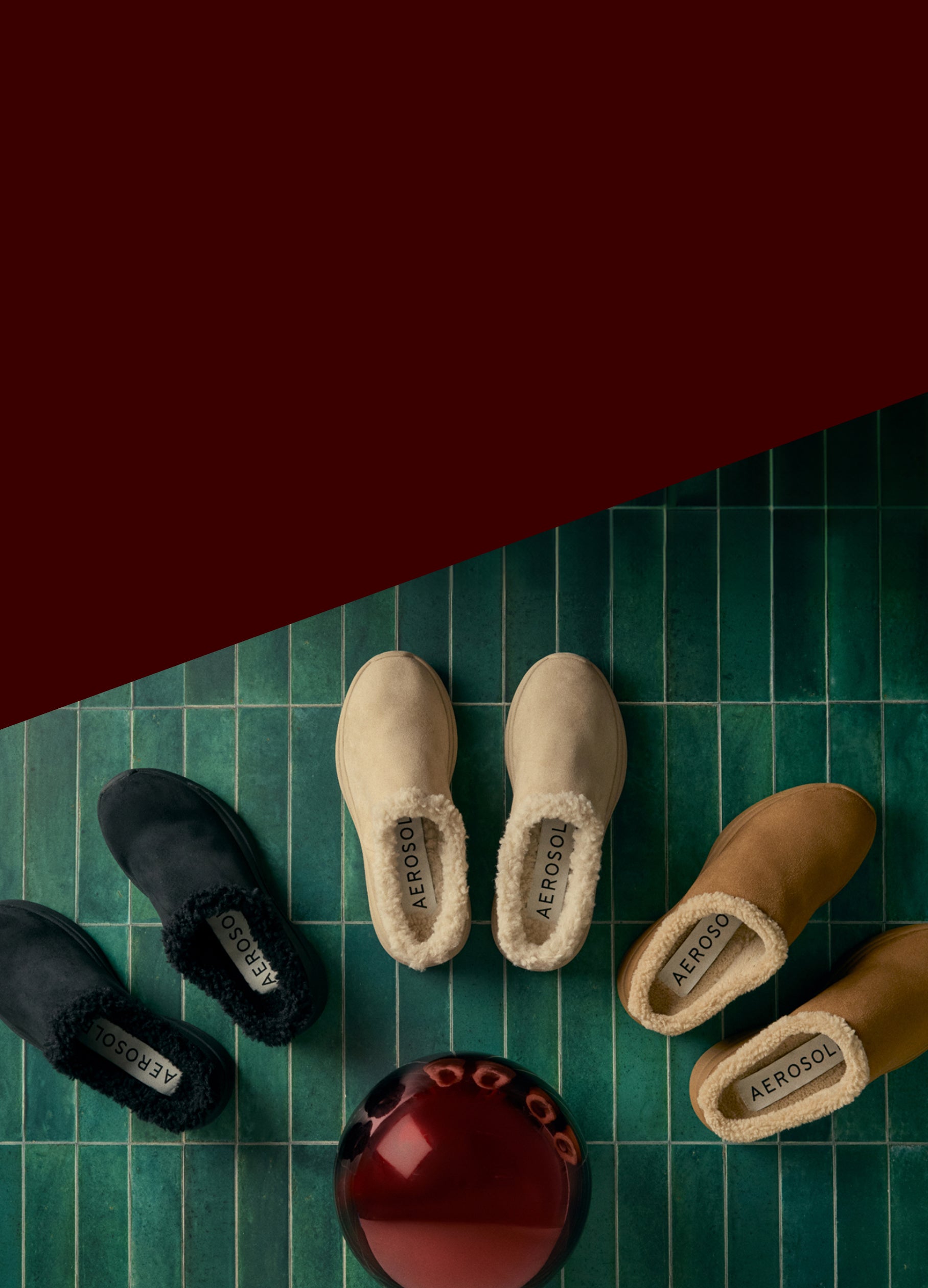 Pair of black shoes, beige slippers, and brown slippers on a green checkered surface. gifts they're sure to love. cozy comforts shop now