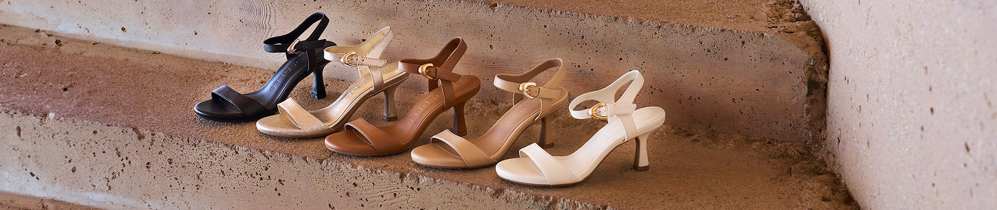 Set of women's sandals in various colors on a stone surface