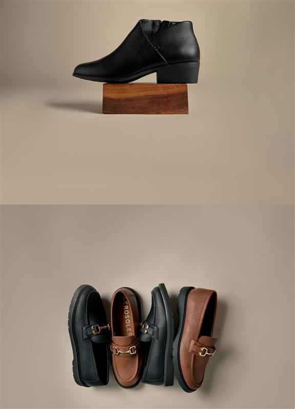 Black leather shoe on a wooden block with three pairs of loafers below on a beige background