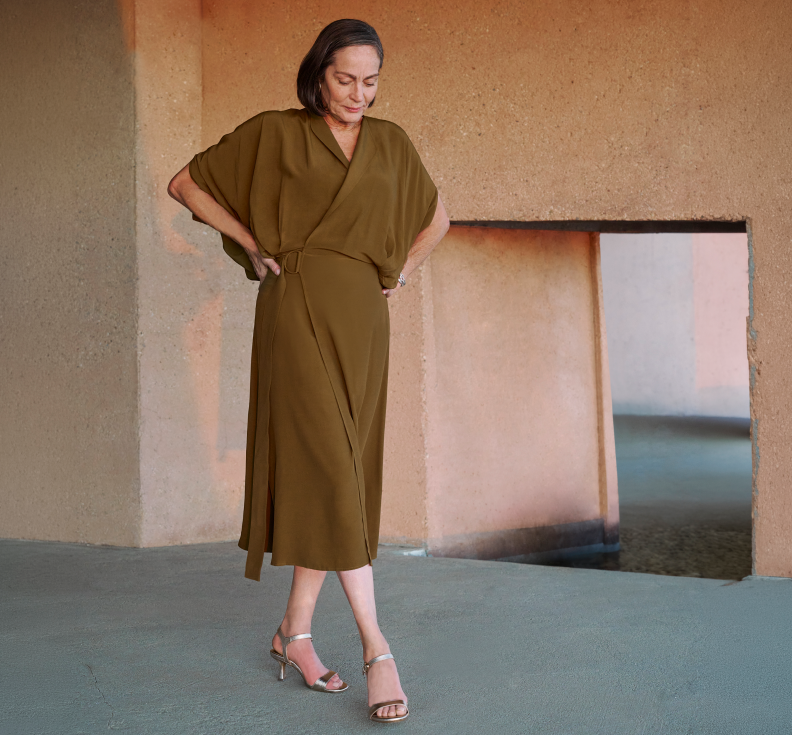 SPRING CELEBRATIONS. Polished pairs for weddings, brunches and all the festivities . Woman wearing a green dress standing in front of a textured wall.